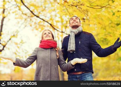 love, relationship, family, season and people concept - smiling couple looking up in autumn park