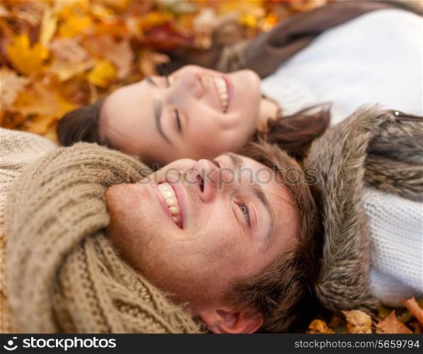love, relationship, season, family and people concept - close up of smiling couple lying in autumn park