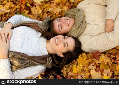 love, relationship, season, family and people concept - close up of smiling couple lying in autumn park