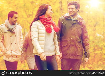 love, relationship, season, friendship and people concept - group of smiling men and women walking in autumn park