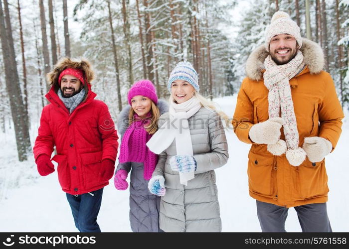 love, relationship, season, friendship and people concept - group of smiling men and women running in winter forest