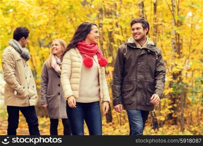 love, relationship, season, friendship and people concept - group of smiling men and women walking in autumn park