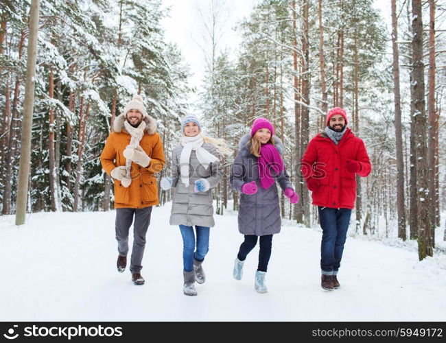 love, relationship, season, friendship and people concept - group of smiling men and women running in winter forest