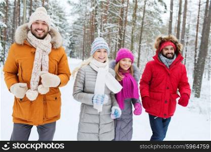 love, relationship, season, friendship and people concept - group of smiling men and women running in winter forest