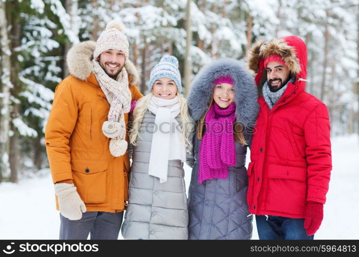 love, relationship, season, friendship and people concept - group of smiling men and women walking in winter forest