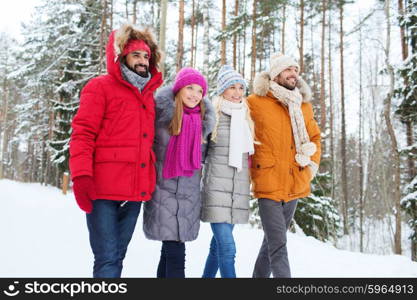 love, relationship, season, friendship and people concept - group of smiling men and women walking in winter forest