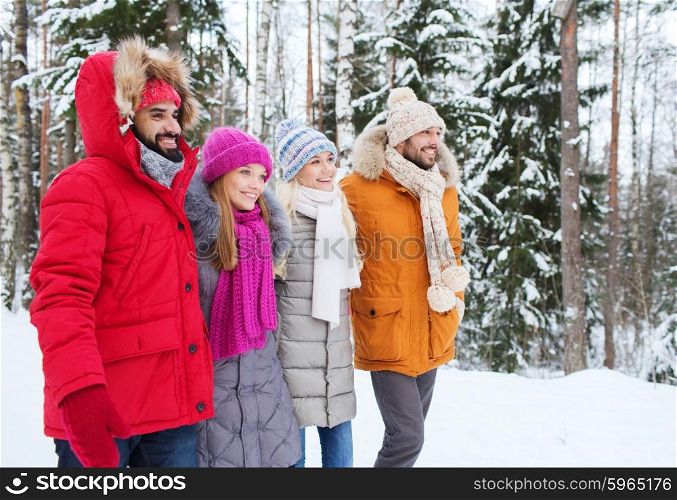 love, relationship, season, friendship and people concept - group of smiling men and women walking in winter forest