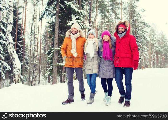 love, relationship, season, friendship and people concept - group of smiling men and women walking in winter forest