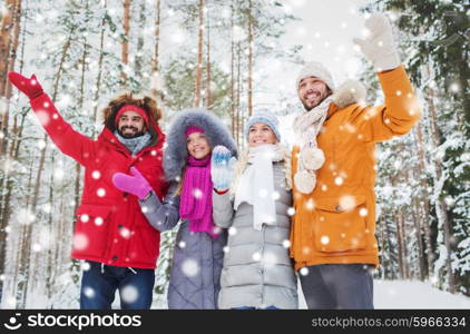 love, relationship, season, friendship and people concept - group of smiling men and women waving hands in winter forest