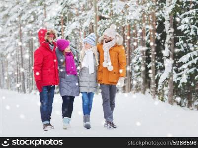 love, relationship, season, friendship and people concept - group of smiling men and women walking and talking in winter forest. group of smiling men and women in winter forest