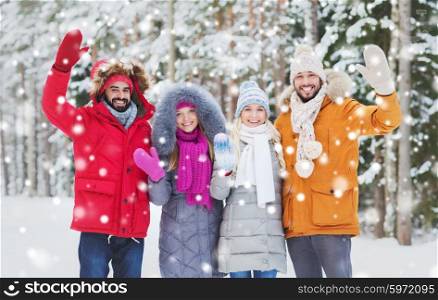 love, relationship, season, friendship and people concept - group of smiling men and women waving hands in winter forest