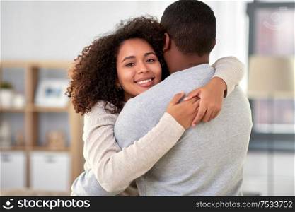 love, relationships and people concept - happy african american couple hugging at home. happy african american couple hugging at home