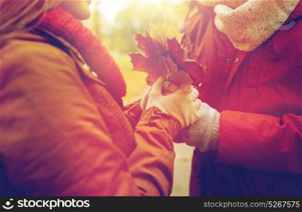 love, relationships, season and people concept - close up of happy couple with autumn maple leaves. close up of happy couple with autumn maple leaves