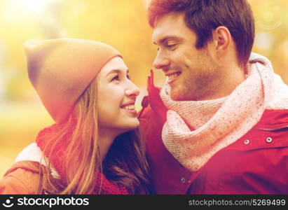 love, relationships, season and people concept - close up of happy young couple walking in autumn park and talking. close up of happy couple walking in autumn park