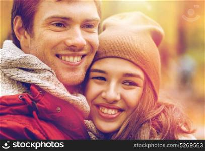 love, relationships, season and people concept - close up of happy young couple walking in autumn park. close up of happy young couple in autumn park