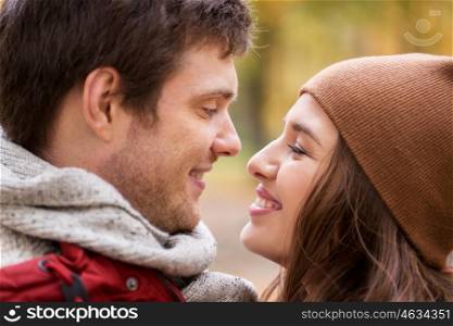 love, relationships, season and people concept - close up of happy young couple kissing outdoors