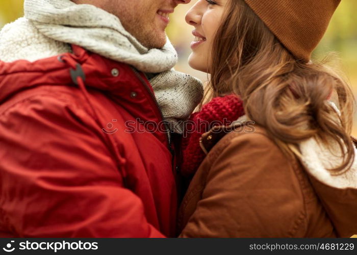 love, relationships, season and people concept - close up of happy young couple kissing outdoors