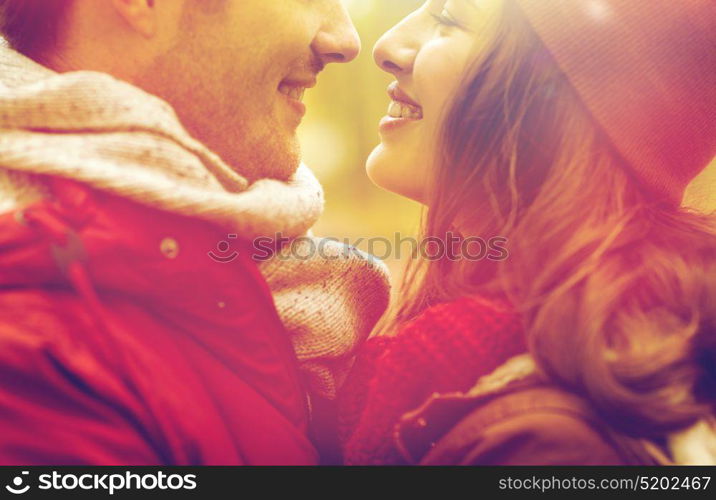 love, relationships, season and people concept - close up of happy young couple kissing outdoors. close up of happy young couple kissing outdoors