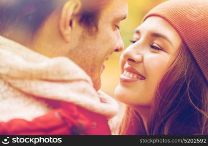 love, relationships, season and people concept - close up of happy young couple kissing outdoors. close up of happy young couple kissing outdoors