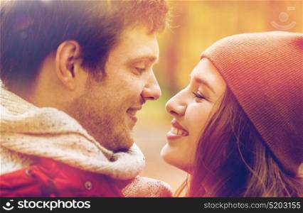 love, relationships, season and people concept - close up of happy young couple kissing outdoors. close up of happy young couple kissing outdoors