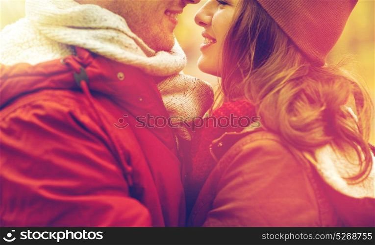 love, relationships, season and people concept - close up of happy young couple kissing outdoors. close up of happy young couple kissing outdoors