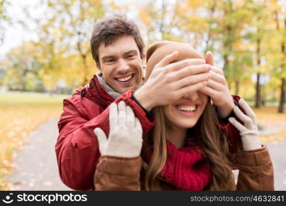 love, relationships, season and people concept - happy young couple having fun in autumn park