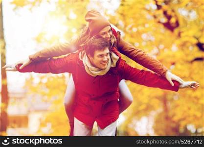 love, relationships, season and people concept - happy young couple having fun in autumn park. happy young couple having fun in autumn park