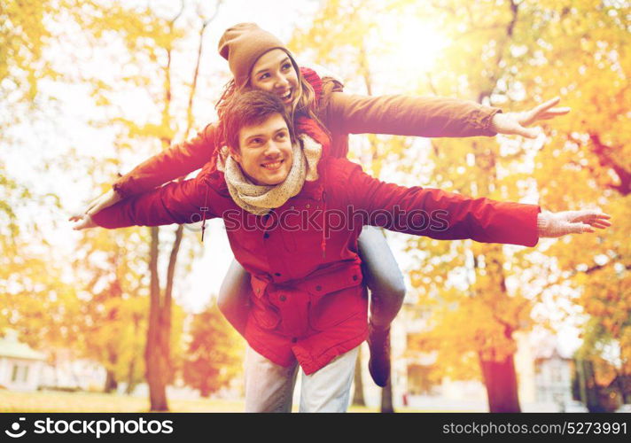 love, relationships, season and people concept - happy young couple having fun in autumn park. happy young couple having fun in autumn park