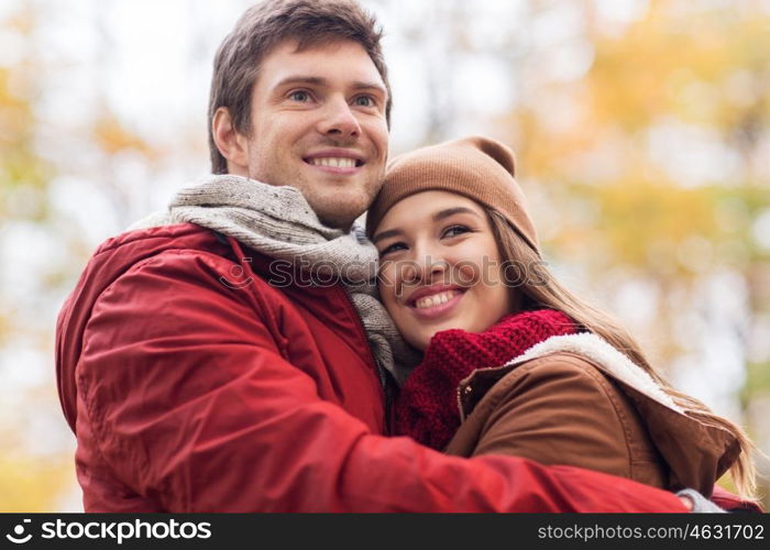 love, relationships, season and people concept - happy young couple hugging in autumn park