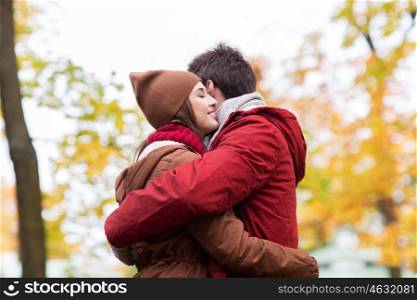 love, relationships, season and people concept - happy young couple hugging in autumn park