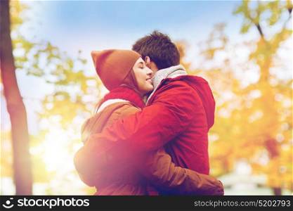 love, relationships, season and people concept - happy young couple hugging in autumn park. happy young couple hugging in autumn park