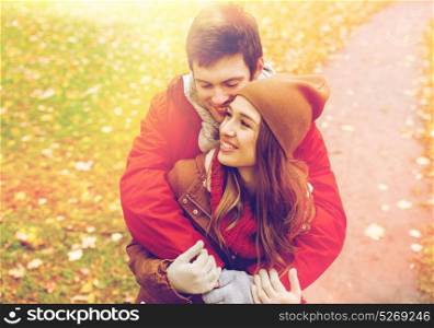 love, relationships, season and people concept - happy young couple hugging in autumn park. happy young couple hugging in autumn park