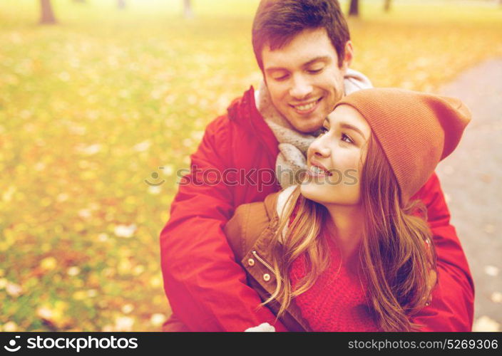 love, relationships, season and people concept - happy young couple hugging in autumn park. happy young couple hugging in autumn park