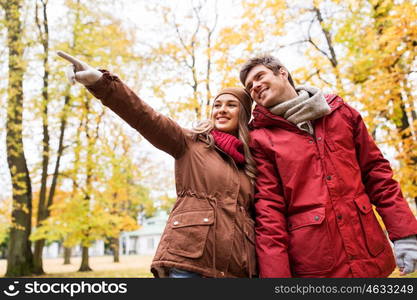 love, relationships, season and people concept - happy young couple walking in autumn park