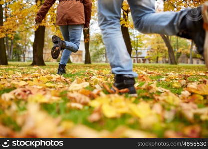 love, relationships, season and people concept - young couple running in autumn park. young couple running in autumn park