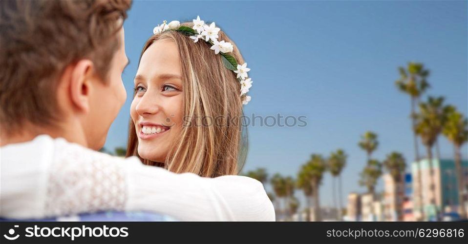 love, romance and people concept - close up of happy smiling young hippie couple hugging over venice beach background in california. close up of happy smiling young hippie couple. close up of happy smiling young hippie couple
