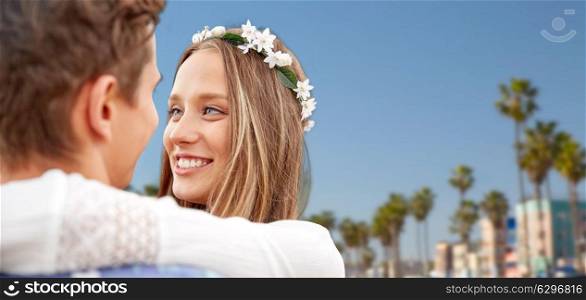 love, romance and people concept - close up of happy smiling young hippie couple hugging over venice beach background in california. close up of happy smiling young hippie couple. close up of happy smiling young hippie couple