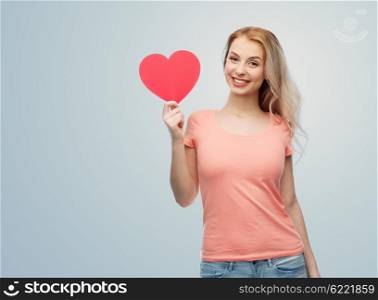 love, romance, charity, valentines day and people concept - smiling young woman or teenage girl with blank red heart shape over gray background