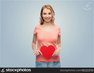 love, romance, charity, valentines day and people concept - smiling young woman or teenage girl with blank red heart shape over gray background