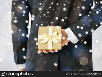 love, romance, holiday, celebration concept - man hiding gift box