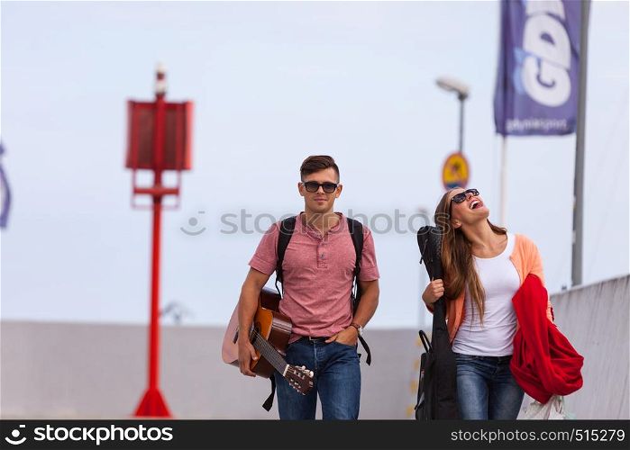Love romance music sound relationship dating concept. Musical couple walking with instruments. Girl and boy taking walk with guitar. . Musical couple walking with instruments.