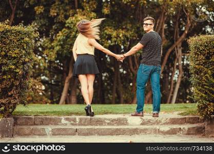 Love romance relationship dating concept. Couple in park taking walk. Girlfriend and boyfriend spending time together.. Couple in park taking walk.