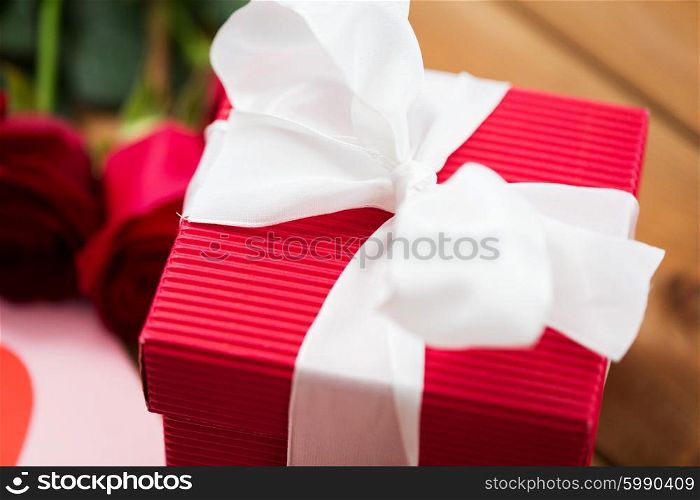love, romance, valentines day and holidays concept - close up of red gift box with white bow