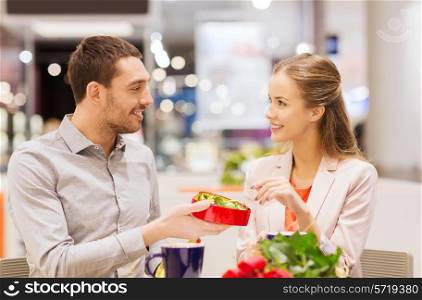 love, romance, valentines day, couple and people concept - happy young couple with red flowers and open gift box in at cafe mall