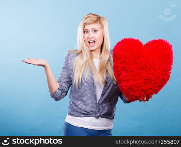 Love, romance, valentines day gift idea concept. Happy woman holding big red fluffy pillow in heart shape. Happy woman holding red pillow in heart shape