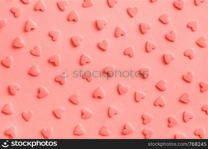 Love romantic pattern. Pink confectionery hearts sprinkles on pink, background, texture Coral toned.. Love romantic pattern. Pink confectionery hearts sprinkles on pink, background, texture Coral toned