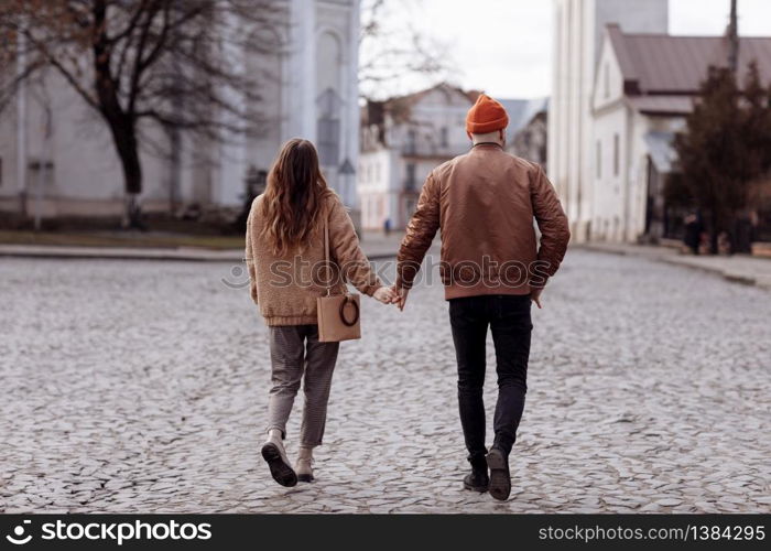 Love story of the beautiful young man and woman walking on the open air the city. embrace on a city walk. copy space. loving couple walking in the city in the open air.. Love story of the beautiful young man and woman walking on the open air the city. embrace on a city walk. copy space. loving couple walking in the city in the open air