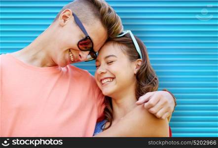 love, summer and people concept - happy smiling teenage couple with sunglasses hugging over blue ribbed background. happy teenage couple with sunglasses hugging