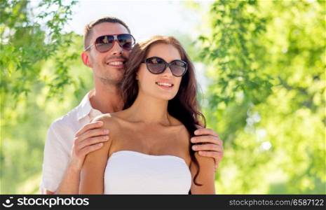 love, summer and relationships concept - happy couple hugging over green natural background. happy couple hugging over green natural background