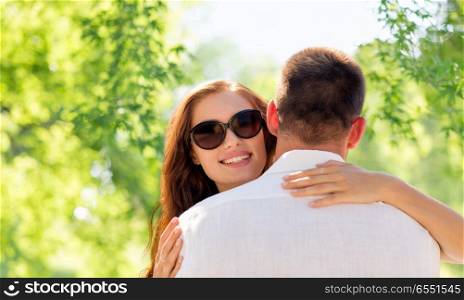 love, summer and relationships concept - happy couple hugging over green natural background. happy couple hugging. happy couple hugging